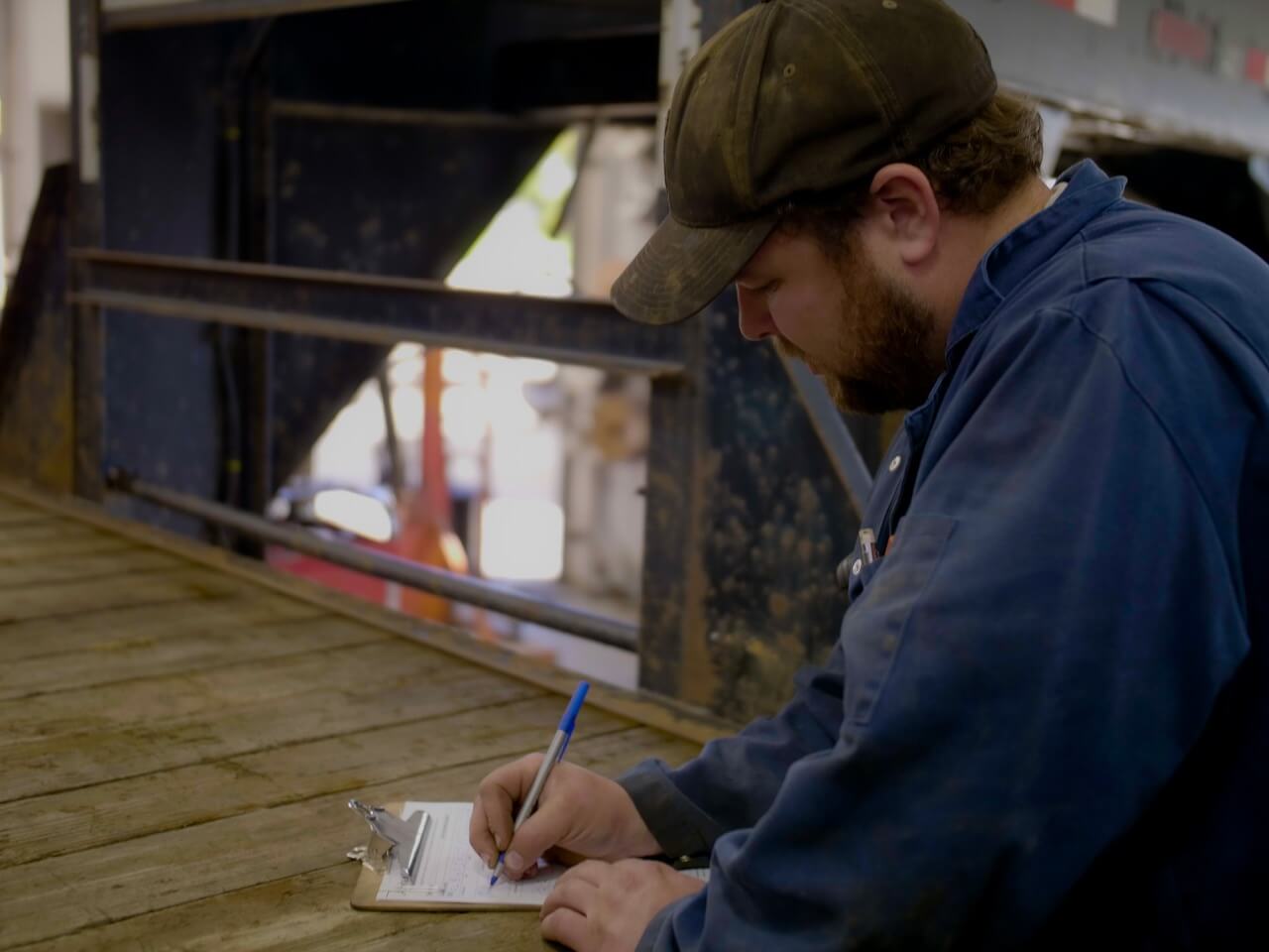 Professional mechanic filling out a service report.
