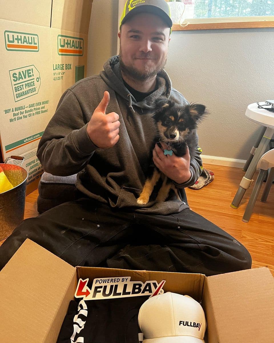 Picture of Pro-siteservices owner Jordan giving thumbs up while holding small dog. 